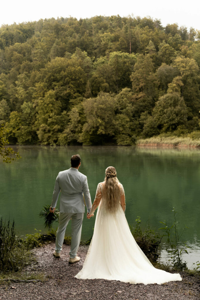 Paar blickt auf den Thalersee mit Wald, Totale.