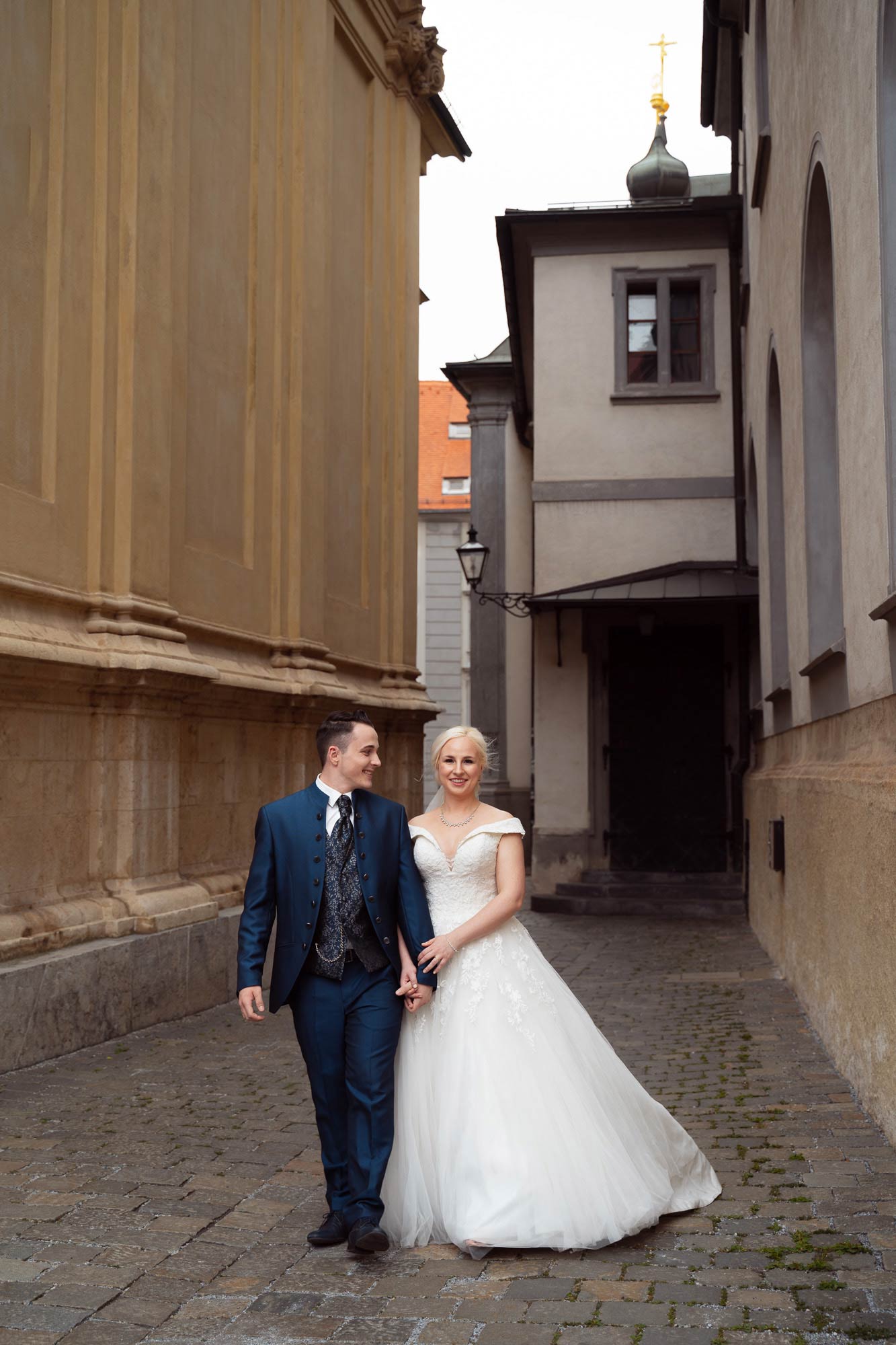 Das Brautpaar spaziert beim After Wedding Shooting durch eine enge Gasse beim Grazer Dom.
